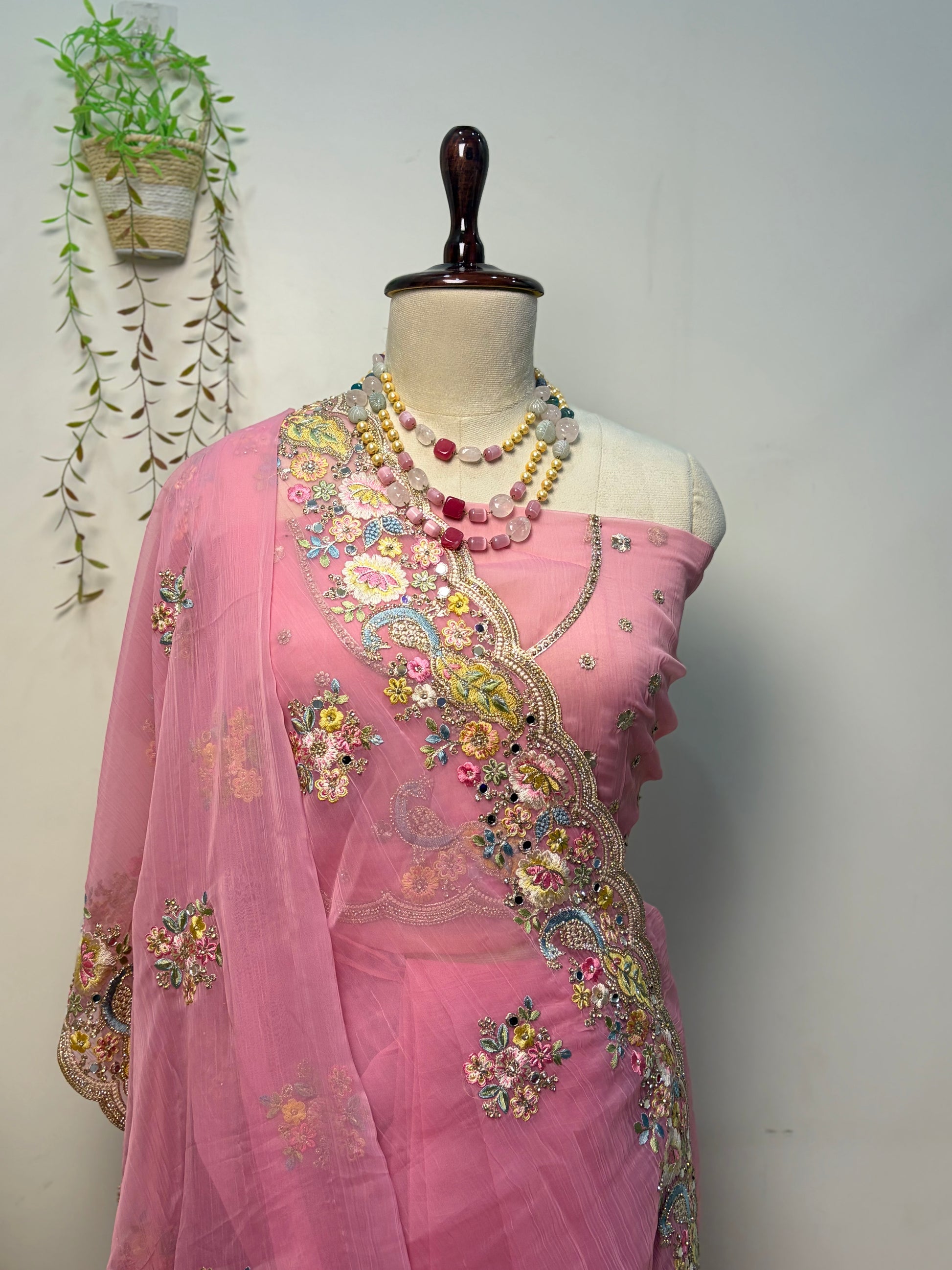 Elegant soft pink Vaaari chiffon saree with floral embroidery and embellished border.
