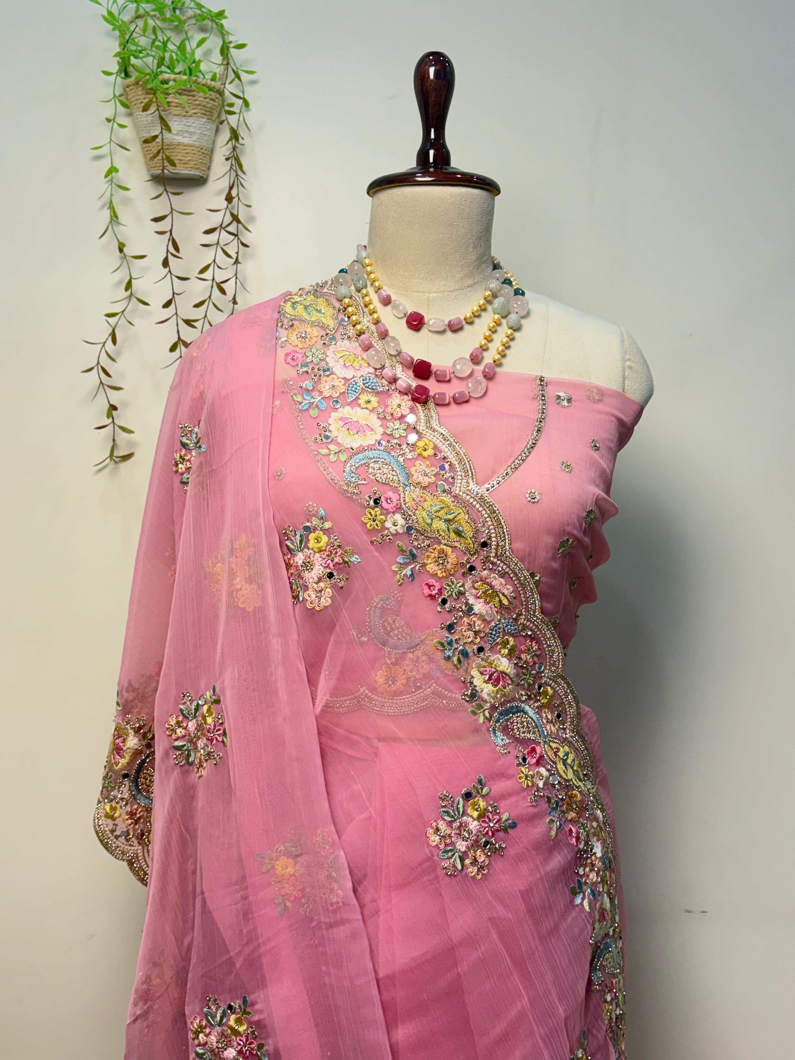 Elegant soft pink Vaaari chiffon saree with floral embroidery and embellished border.
