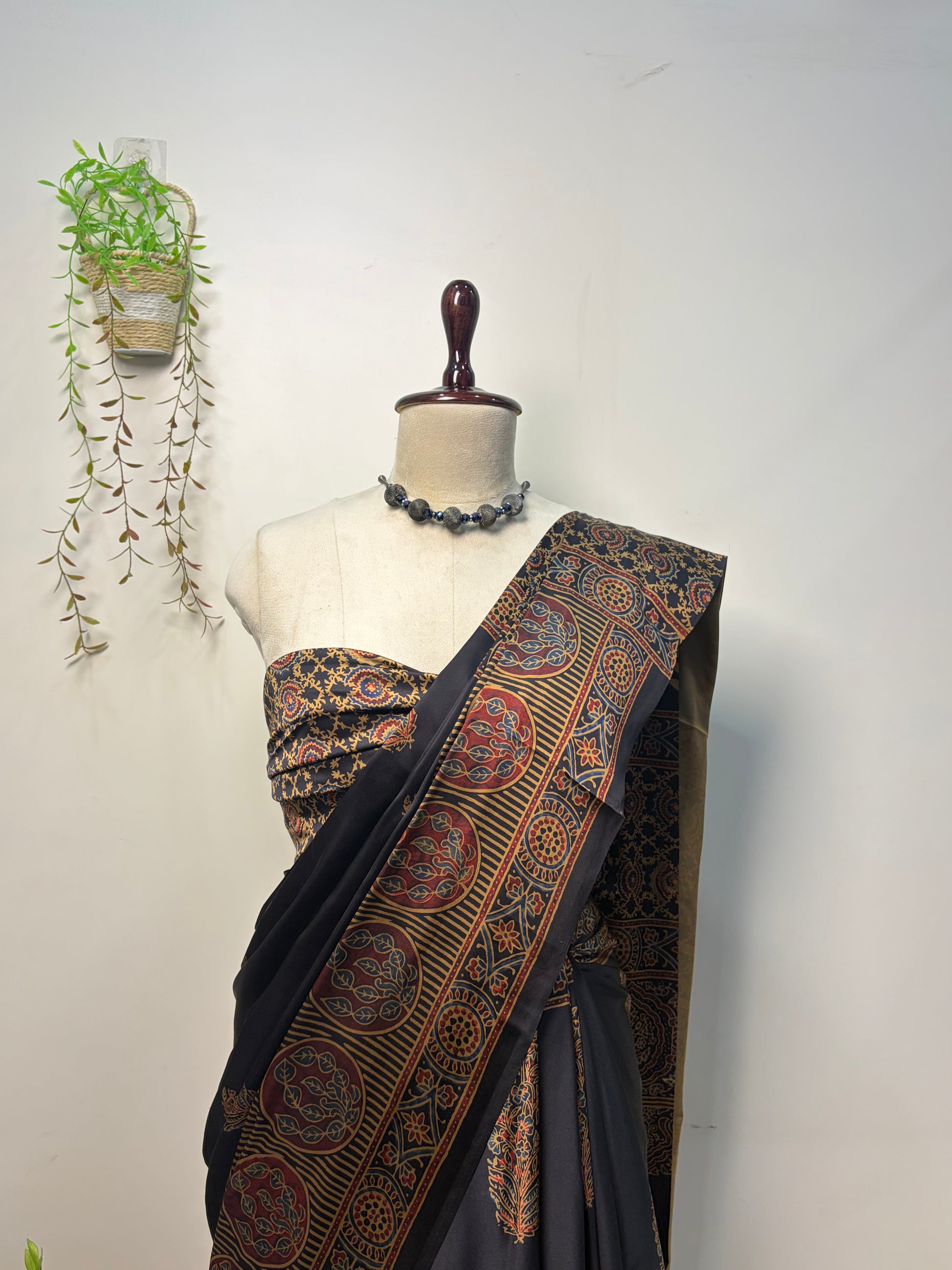 Black Modal Silk Ajrak Saree displayed on mannequin with traditional woven border and elegant ethnic design, perfect for festive and party wear.