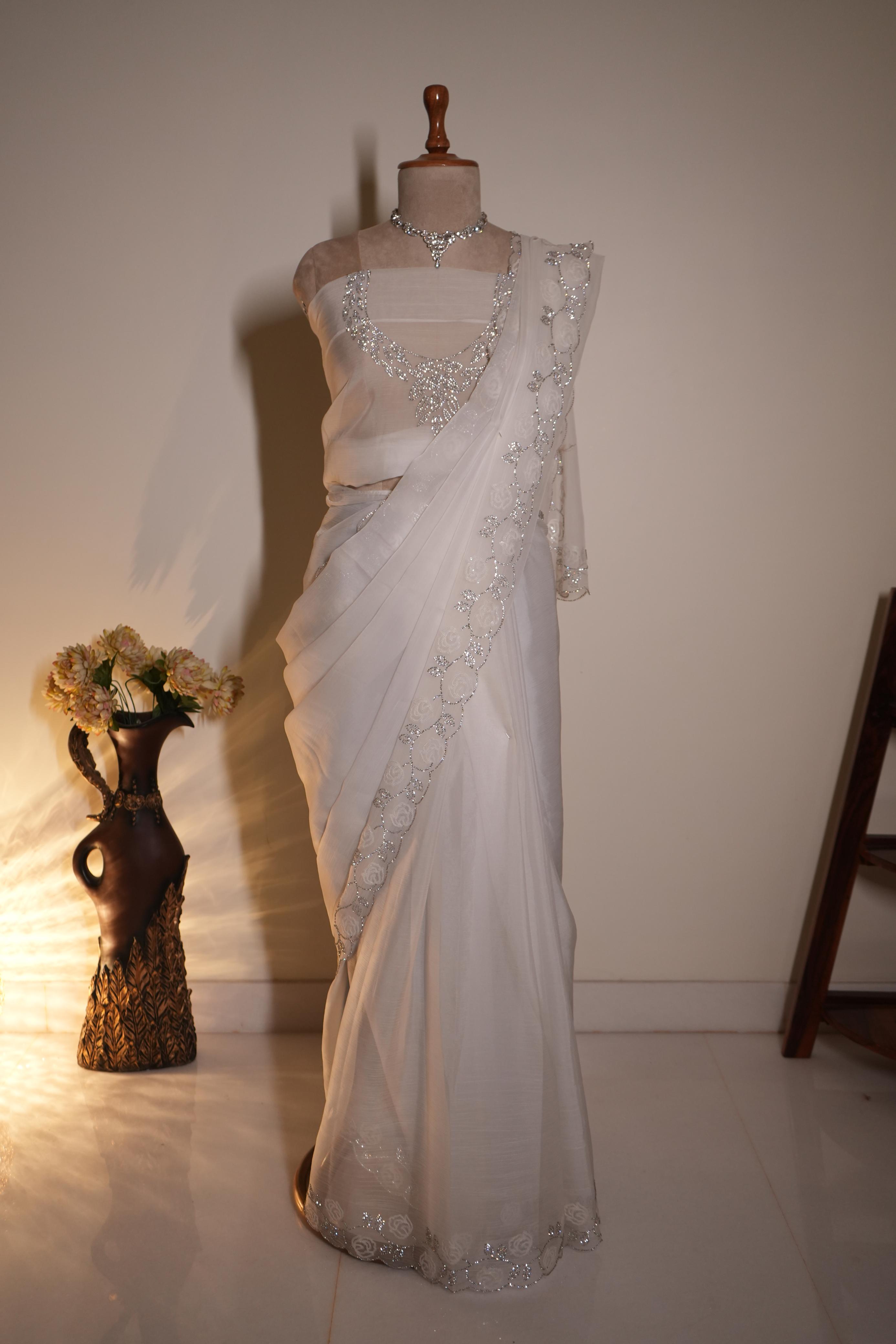 White chiffon saree with intricate stone work and elegant border, perfect for wedding and party wear