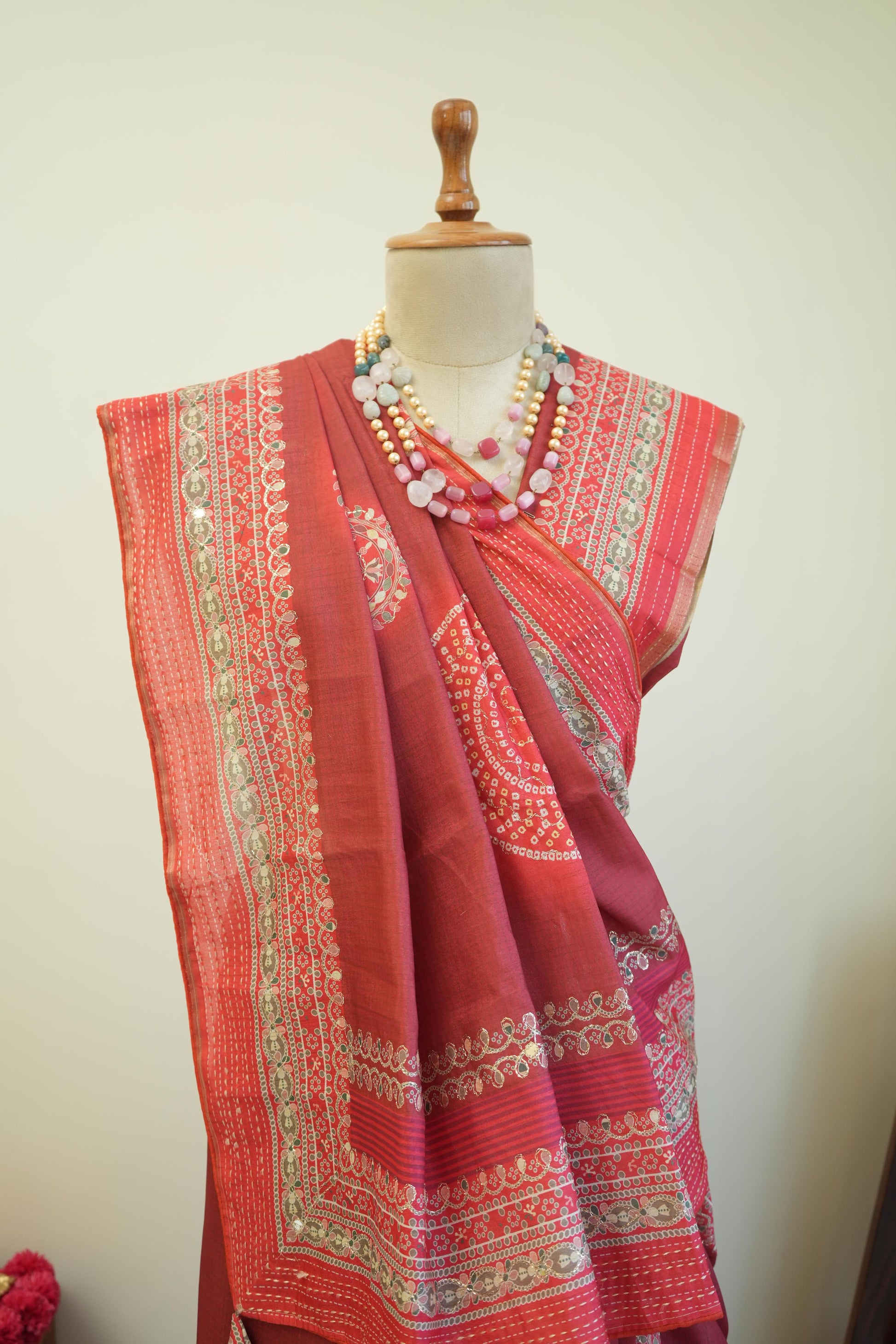 This red cotton saree with printed design and border detailing is a comfortable casual wear saree for women.