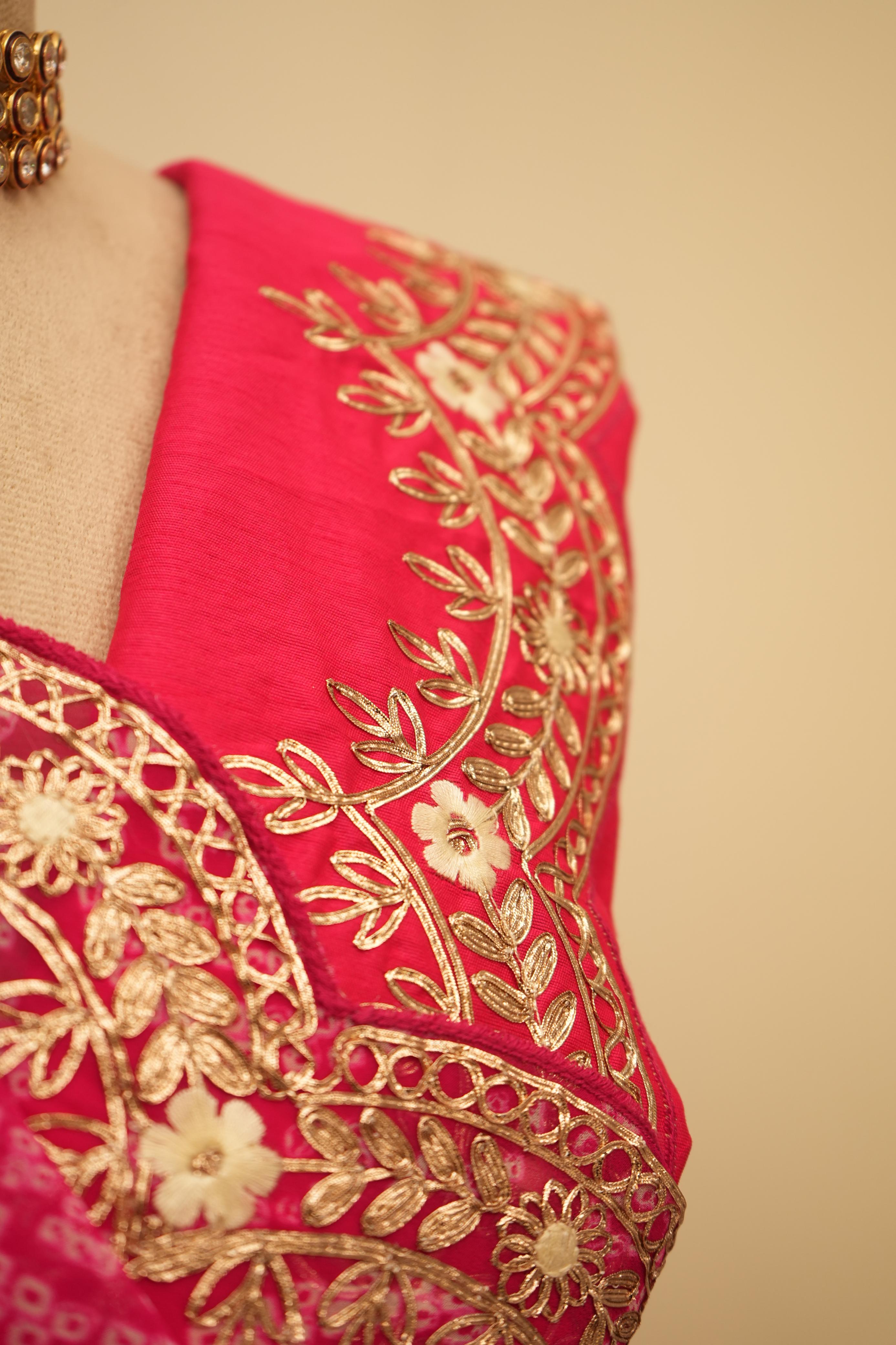This jaipuri bandhani saree in rani color with traditional patterns and embroidery work border is an ideal bhanej saree for festive occasions.